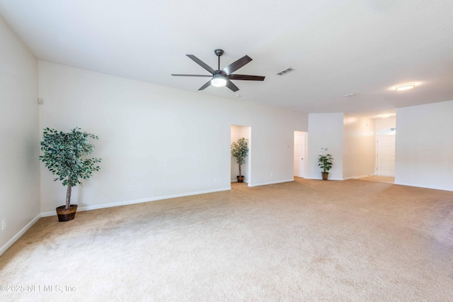 spare room with baseboards, light carpet, and a ceiling fan