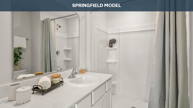 bathroom with vanity, curtained shower, and toilet