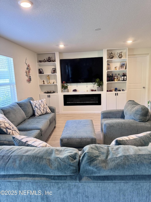 living room featuring a textured ceiling and light hardwood / wood-style floors