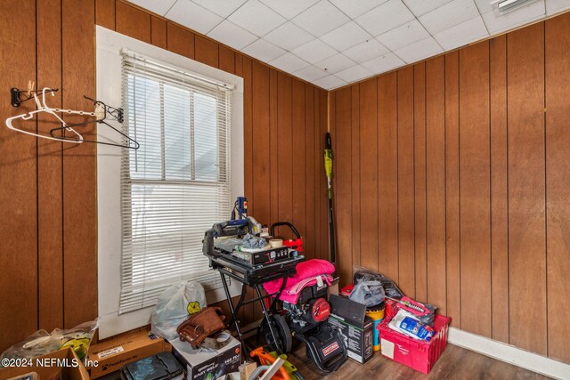 misc room featuring hardwood / wood-style flooring and wooden walls