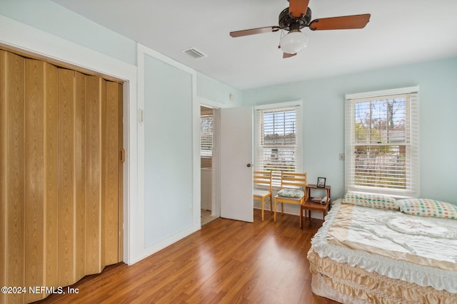 bedroom with wood-type flooring, a closet, and ceiling fan