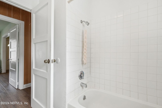 bathroom with wood-type flooring and tiled shower / bath