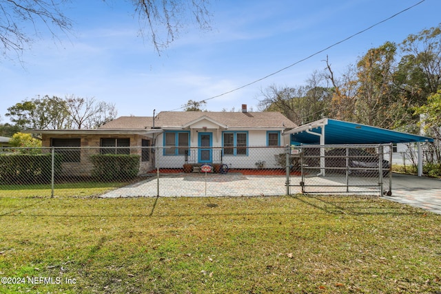 rear view of property with a carport and a yard