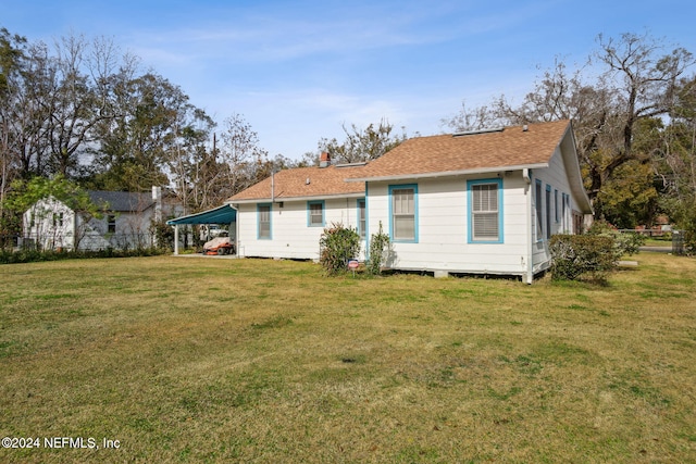 back of property featuring a carport and a lawn