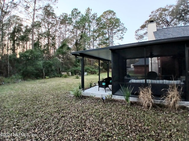 view of yard featuring a patio and a sunroom