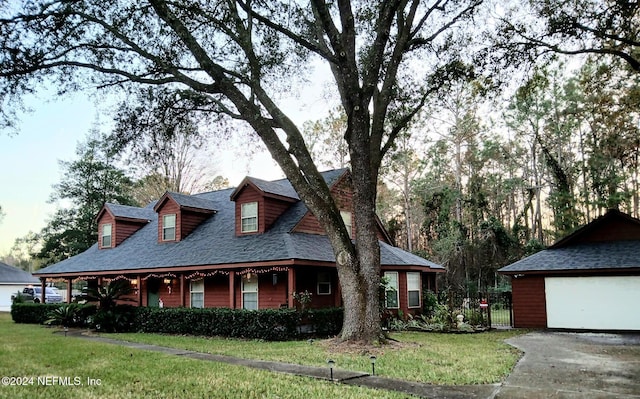 view of front facade featuring a front yard, a garage, and an outdoor structure