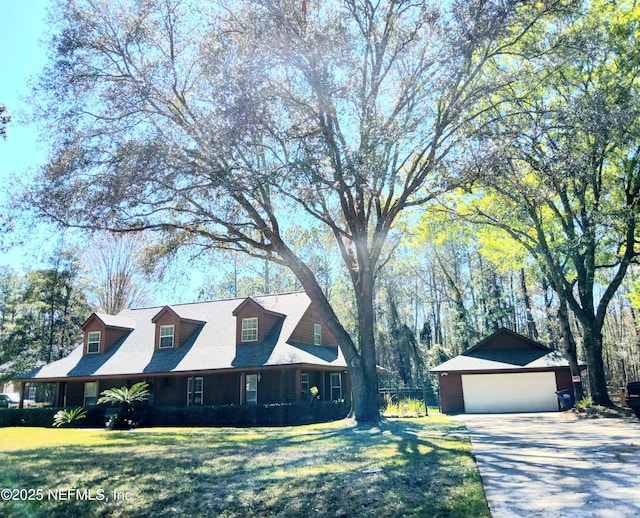 cape cod-style house with an outbuilding, a front yard, and a detached garage