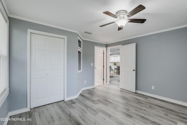 unfurnished bedroom with ceiling fan, a closet, crown molding, and light hardwood / wood-style floors