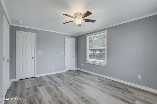 unfurnished room featuring ceiling fan, light wood-type flooring, and ornamental molding