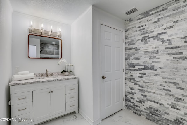 bathroom featuring a shower, vanity, a textured ceiling, and ornamental molding