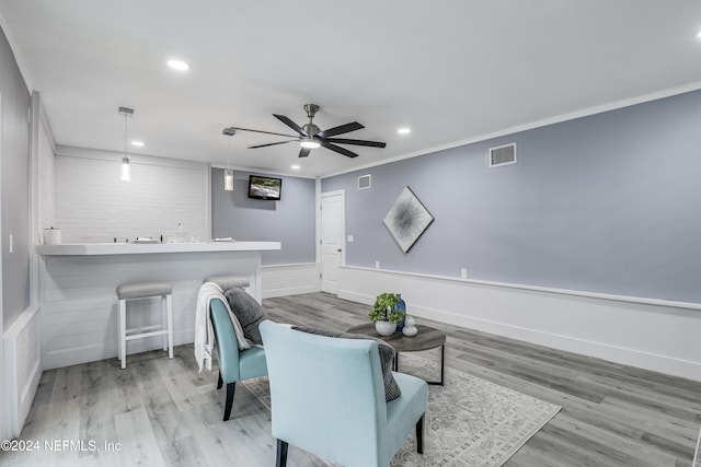 sitting room with crown molding, light hardwood / wood-style flooring, and ceiling fan