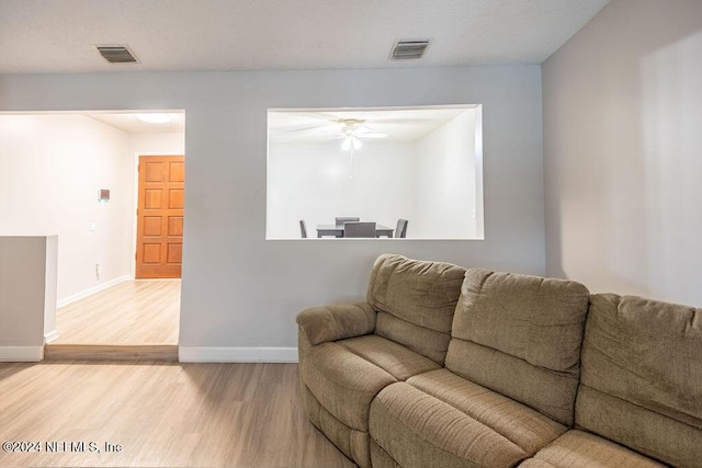 living room featuring ceiling fan and light hardwood / wood-style floors