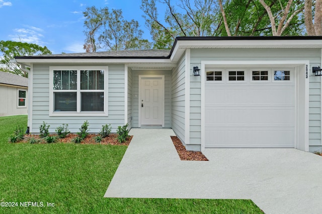 ranch-style home featuring a front lawn and a garage