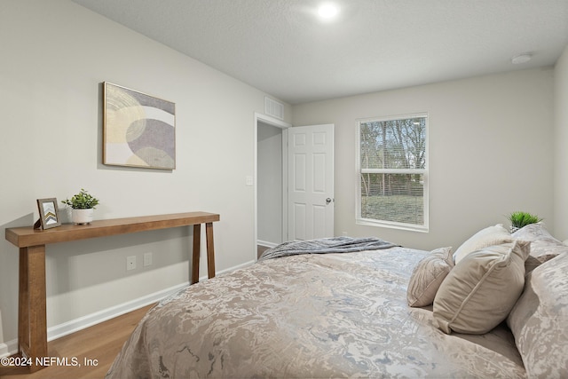 bedroom with a textured ceiling and dark wood-type flooring