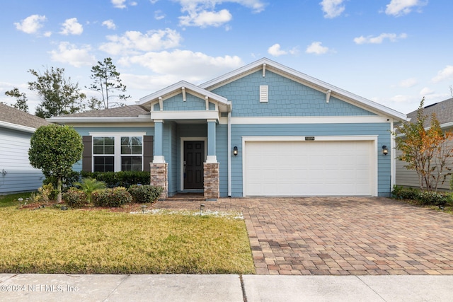 craftsman house featuring a front lawn and a garage