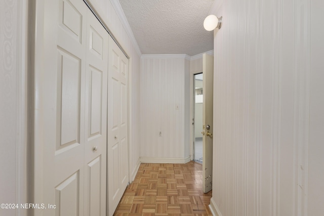 corridor featuring ornamental molding, a textured ceiling, and light parquet floors