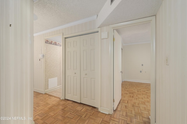 hallway featuring ornamental molding, a textured ceiling, and light parquet flooring