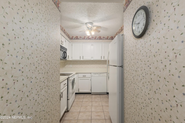 kitchen with a textured ceiling, white appliances, ceiling fan, white cabinets, and light tile patterned flooring