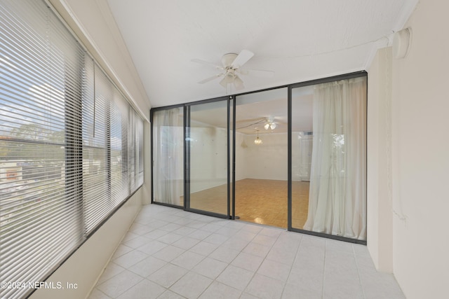 unfurnished sunroom with ceiling fan