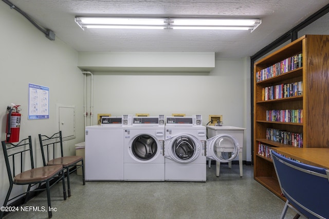 laundry room with a textured ceiling and washing machine and dryer