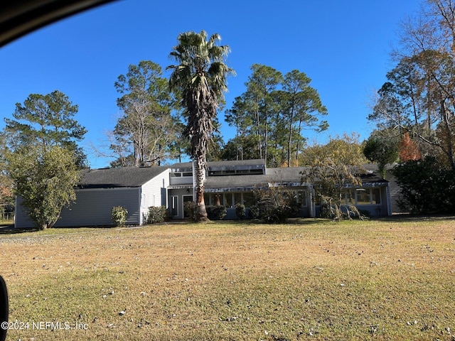 rear view of house featuring a lawn