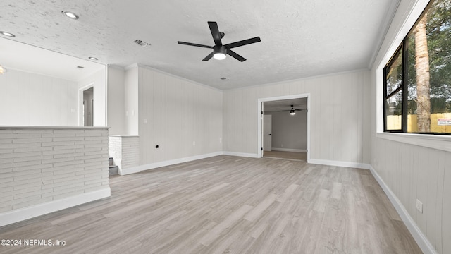 unfurnished living room featuring a textured ceiling, light hardwood / wood-style flooring, ceiling fan, and ornamental molding