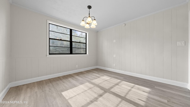 unfurnished room featuring a chandelier, hardwood / wood-style flooring, and ornamental molding