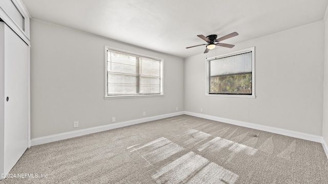 unfurnished bedroom with multiple windows, ceiling fan, a closet, and light colored carpet