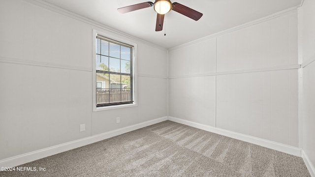 spare room with ceiling fan, crown molding, and carpet