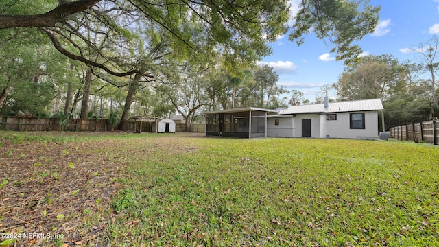 view of yard featuring a sunroom and a storage shed