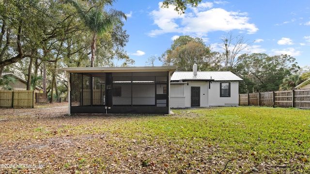 back of house with a lawn and a sunroom