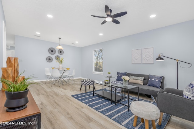 living room with light hardwood / wood-style floors and ceiling fan