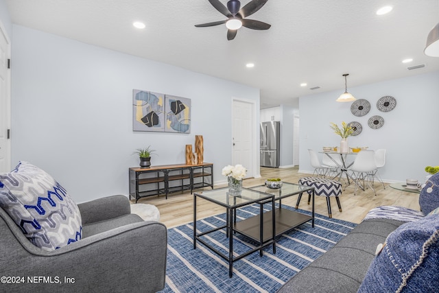 living room with light hardwood / wood-style floors and ceiling fan