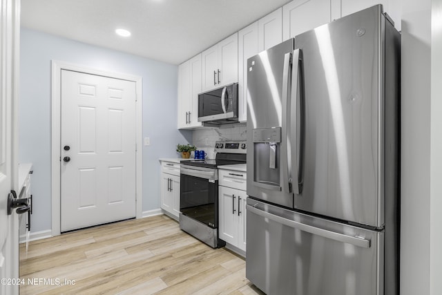 kitchen featuring white cabinets, appliances with stainless steel finishes, tasteful backsplash, and light hardwood / wood-style floors