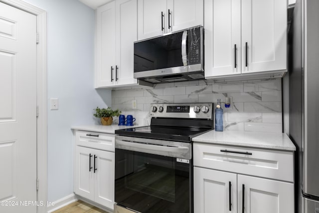 kitchen featuring white cabinets, appliances with stainless steel finishes, and tasteful backsplash