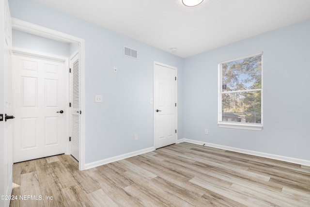 unfurnished bedroom featuring a closet and light hardwood / wood-style floors