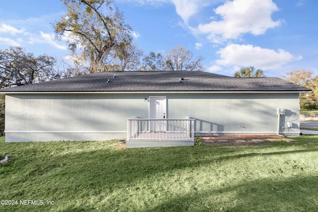 rear view of house with a lawn and a wooden deck