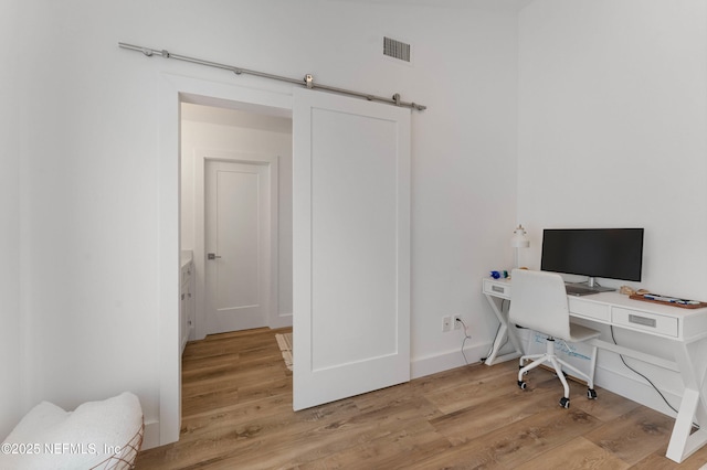 office area featuring a barn door and light wood-type flooring