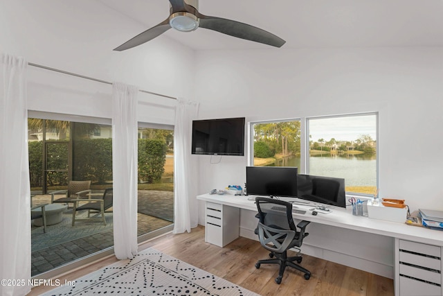 office with built in desk, light hardwood / wood-style floors, and ceiling fan