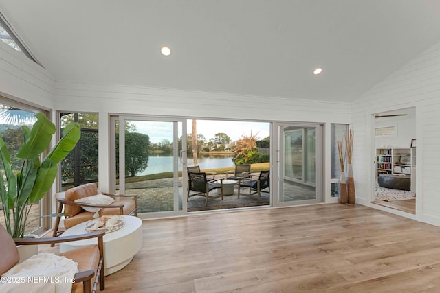 sunroom featuring a water view and lofted ceiling