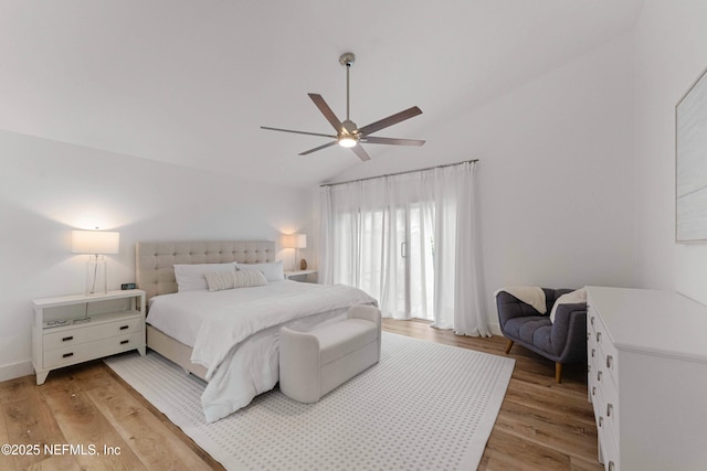 bedroom with ceiling fan, lofted ceiling, and light wood-type flooring