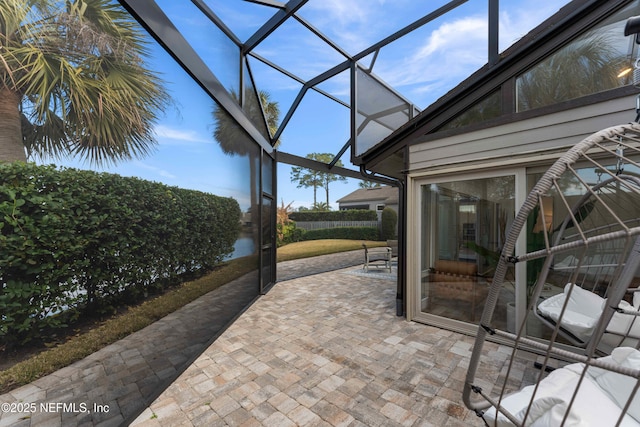 view of patio featuring glass enclosure