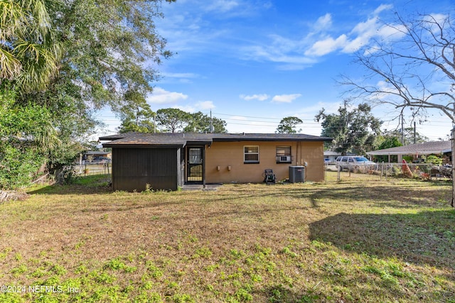 rear view of property with a lawn and central AC unit