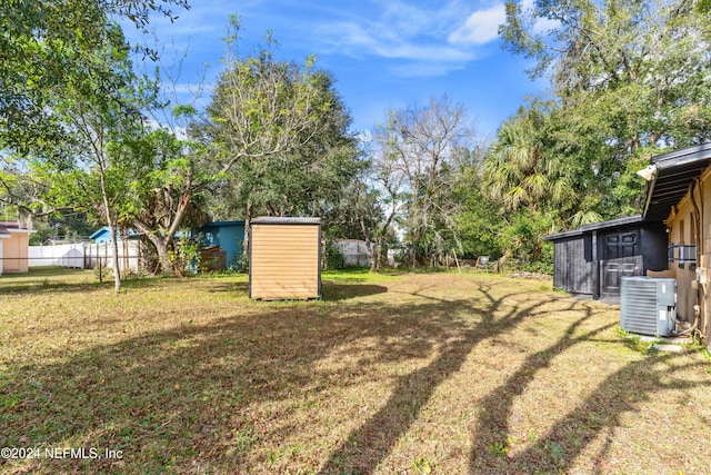 view of yard featuring a storage unit and central AC