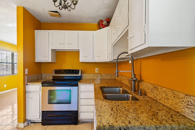 kitchen featuring light stone counters, sink, light tile patterned floors, and stainless steel range with electric stovetop