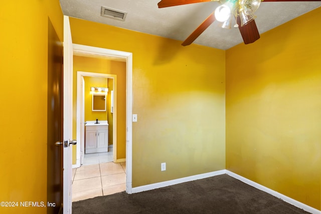 unfurnished room with light carpet, ceiling fan, and sink