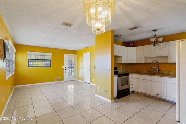 kitchen featuring electric stove, white cabinetry, sink, and a chandelier