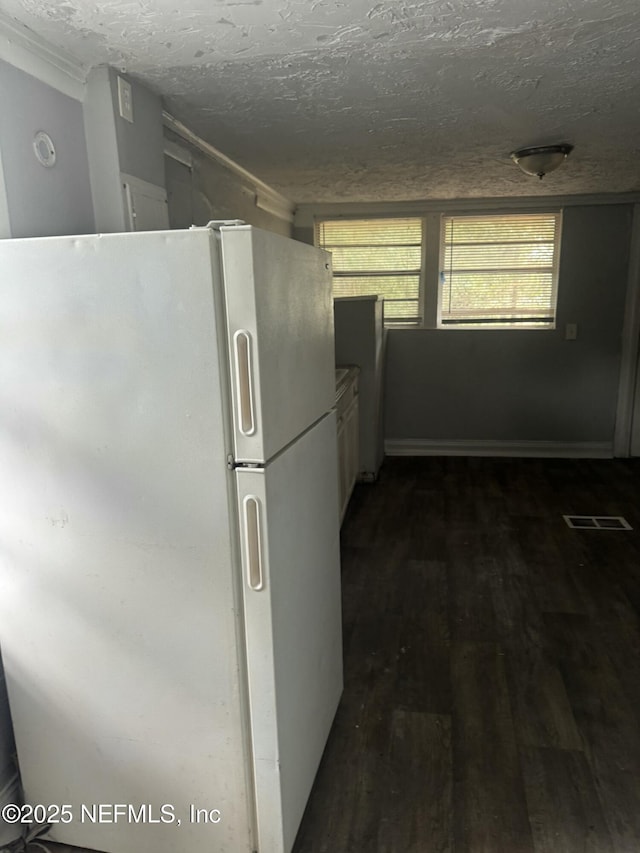 kitchen featuring a textured ceiling, dark hardwood / wood-style floors, and white refrigerator