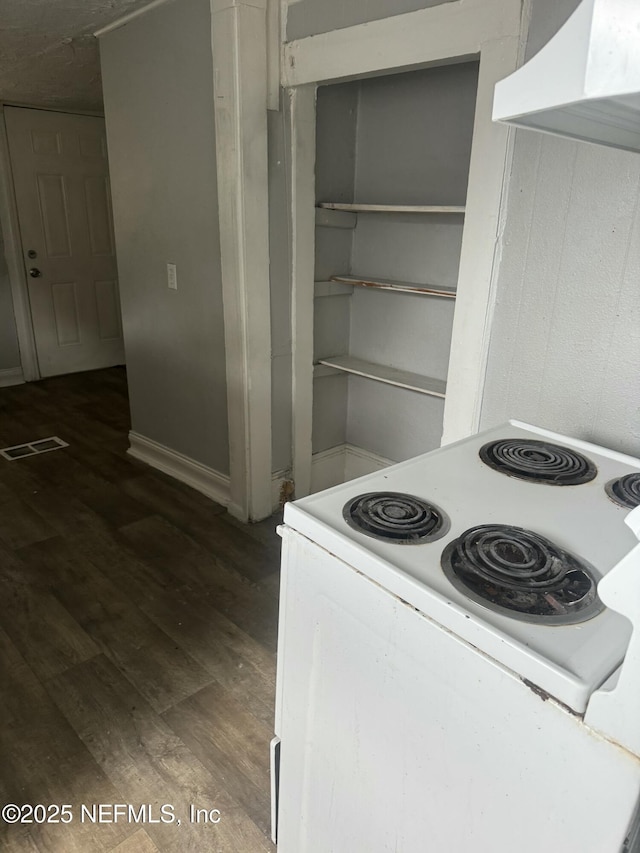 kitchen featuring electric stove, wall chimney exhaust hood, and dark wood-type flooring