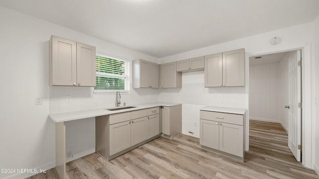 kitchen with gray cabinetry, light hardwood / wood-style floors, and sink